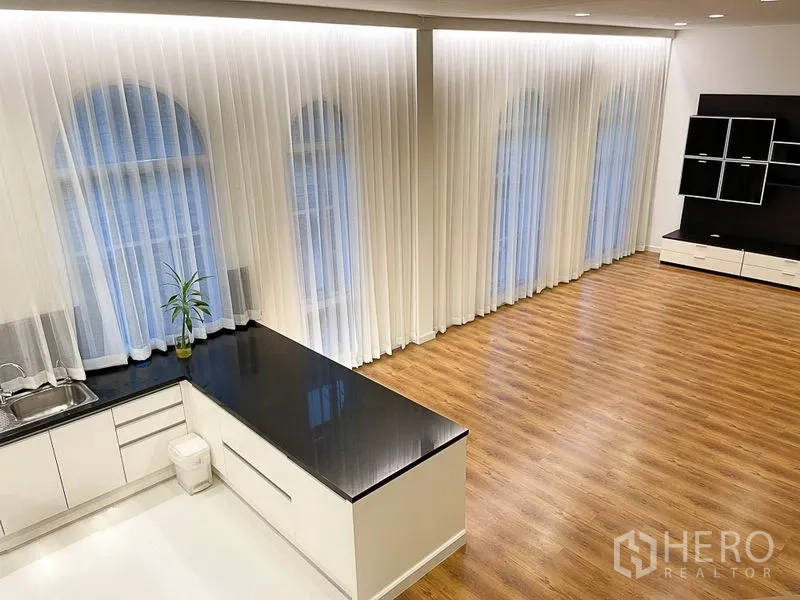 ทาวน์เฮาส์ ให้เช่าในYan Nawa, Bangkok - โถงนั่งเล่นแบบโอเพ่น พื้นไม้ และหน้าต่างโค้งสูง เชื่อมต่อครัวเคาน์เตอร์หิน