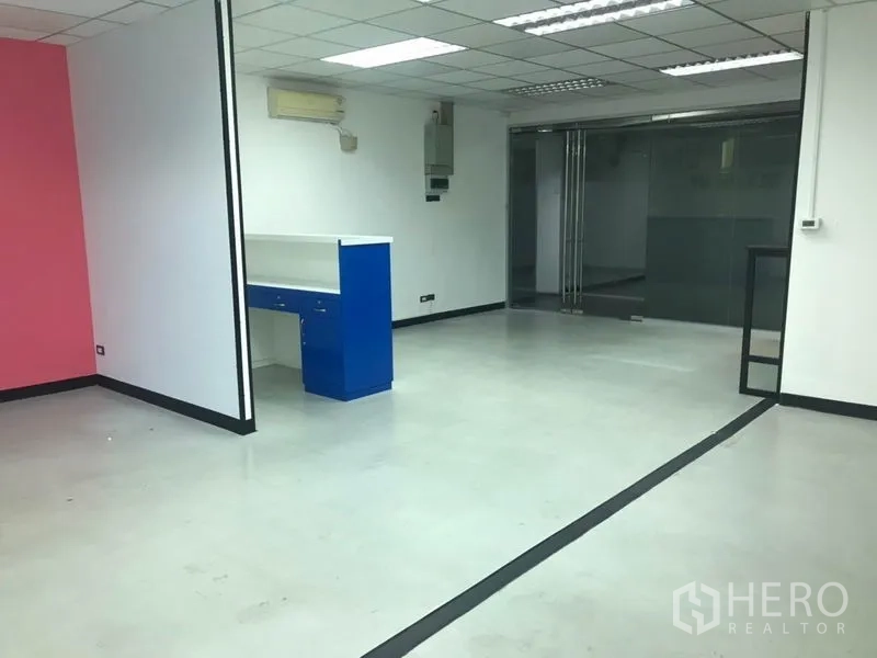 สำนักงาน ให้เช่าในKhlong Toei, Bangkok - โถงสำนักงานกว้าง เคาน์เตอร์ต้อนรับสีน้ำเงิน ประตูกระจกบานเลื่อน และผนังสีชมพู