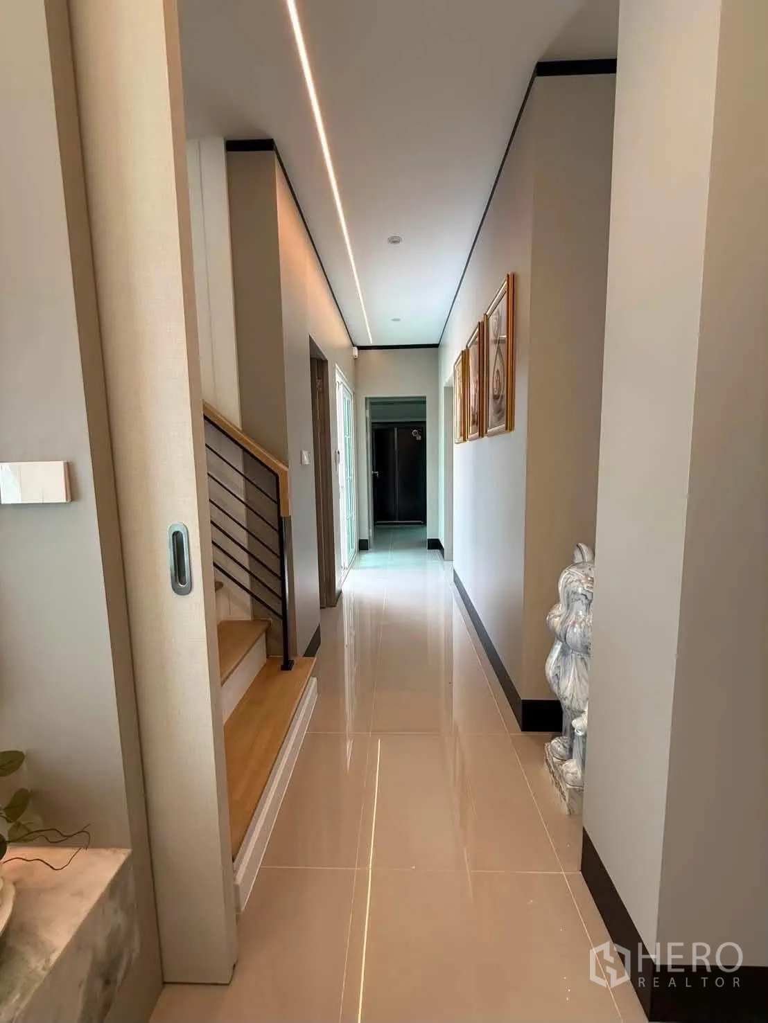 Detached House for rent in Bang Phli, Samut Prakan - Hallway with recessed ceiling lighting leading toward kitchen and stairs.