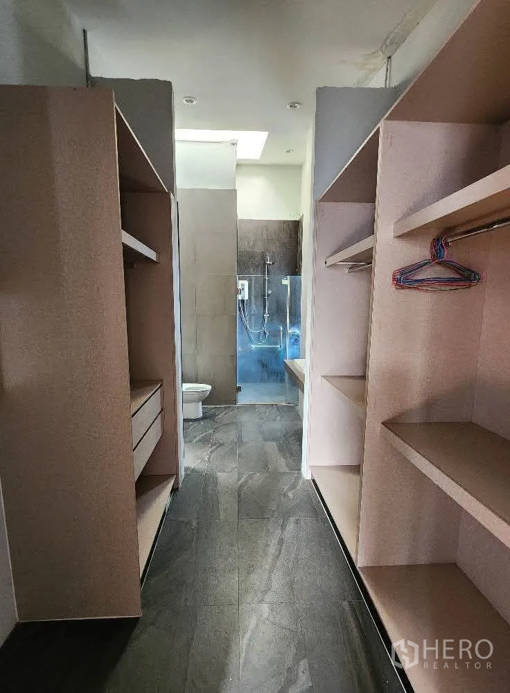 Home Office for rent in Mueang Nonthaburi, Nonthaburi - Corridor with built-in storage leading to a bathroom with glass shower.