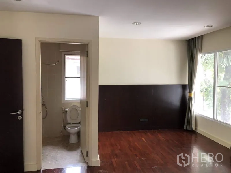 บ้าน ขายในWang Thonglang, Bangkok - ห้องนอนที่สองมีห้องน้ำในตัว พื้นไม้ และหน้าต่างบานใหญ่เห็นวิวสวน.