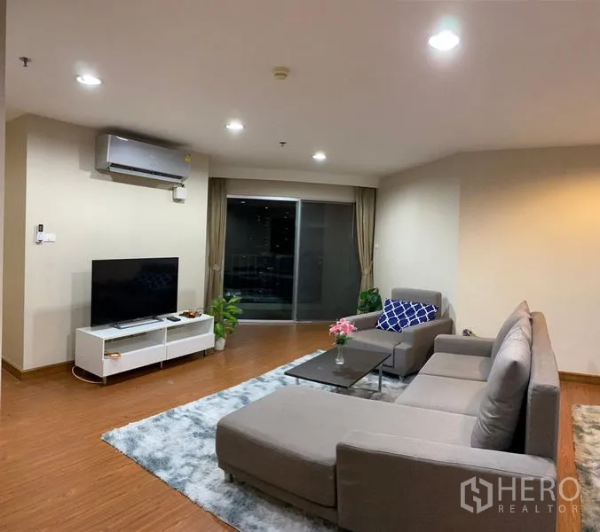 Condominium for rent - Living room with TV console, sliding glass door to balcony, and city views.