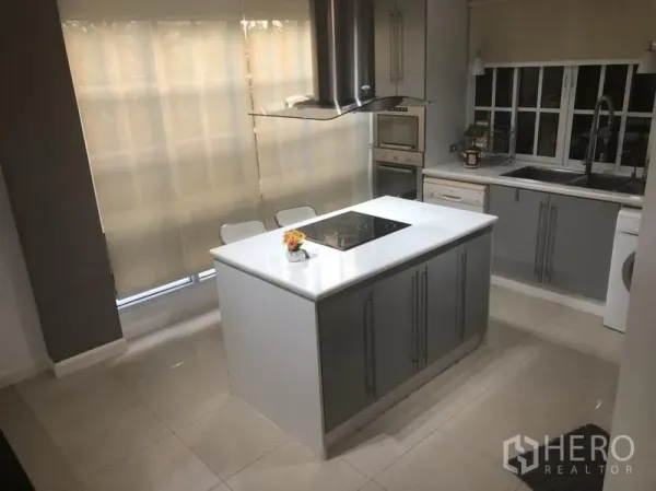 ทาวน์เฮาส์ ให้เช่าในBang Kapi, Bangkok - ครัวสมัยใหม่พร้อมไอส์แลนด์สีขาว เตาไฟฟ้า เตาอบบิวท์อิน และตู้เก็บของ