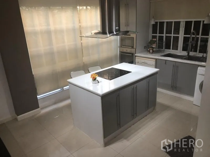 ทาวน์เฮาส์ ให้เช่าในBang Kapi, Bangkok - ครัวสมัยใหม่พร้อมไอส์แลนด์สีขาว เตาไฟฟ้า เตาอบบิวท์อิน และตู้เก็บของ