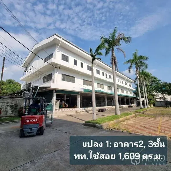 Standalone for rent in Krathum Baen, Samut Sakhon - Three‑storey white office and warehouse building with a covered loading area and a forklift parked in front.