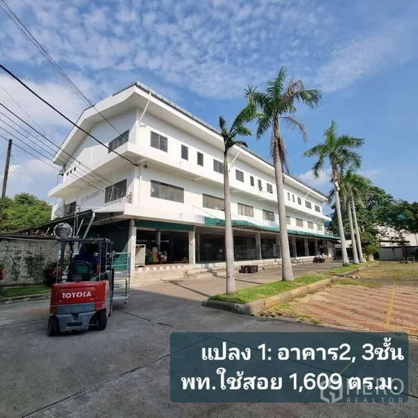 Standalone for rent in Krathum Baen, Samut Sakhon - Three‑storey white office and warehouse building with a covered loading area and a forklift parked in front.