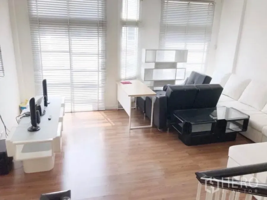 ทาวน์เฮาส์ ให้เช่าในPrawet, Bangkok - ห้องนั่งเล่นสว่าง หน้าต่างบานใหญ่พร้อมมู่ลี่ พื้นไม้ โซฟาสีดำและขาว พร้อมโต๊ะทำงาน