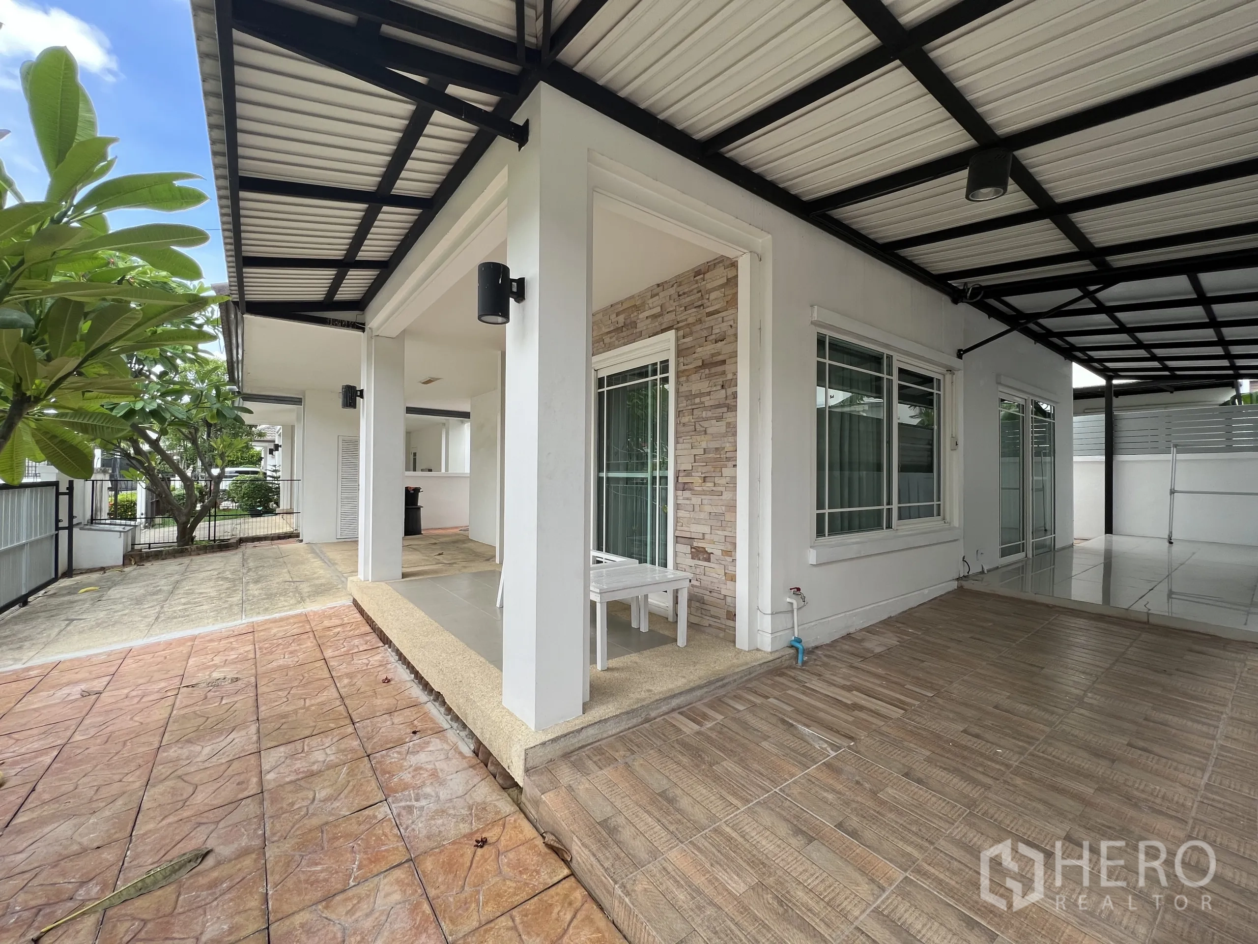 Detached House for rent in Bang Kapi, Bangkok - Corner patio with covered roof and large windows facing the yard.