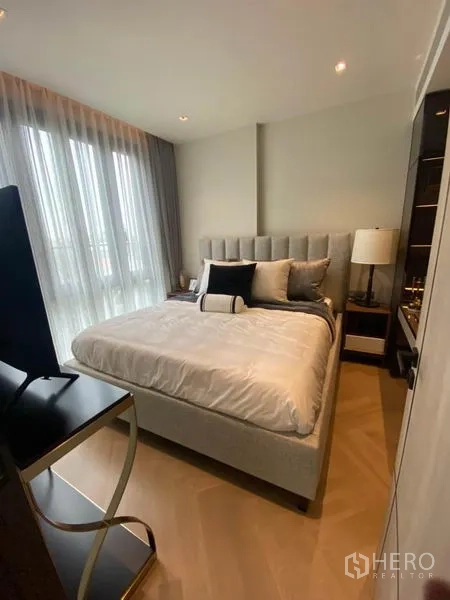 Condominium for rent in Watthana, Bangkok - Cozy bedroom with upholstered bed, soft drapes and floor-to-ceiling windows in an Ekkamai condo.