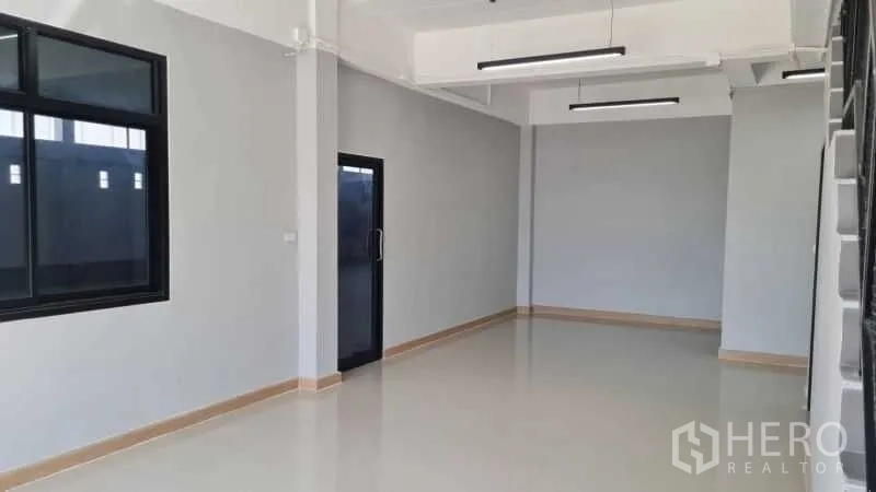 Warehouse for rent in Bang Bua Thong, Nonthaburi - Ground-floor office room with tiled floor, large window, and glass entry door.