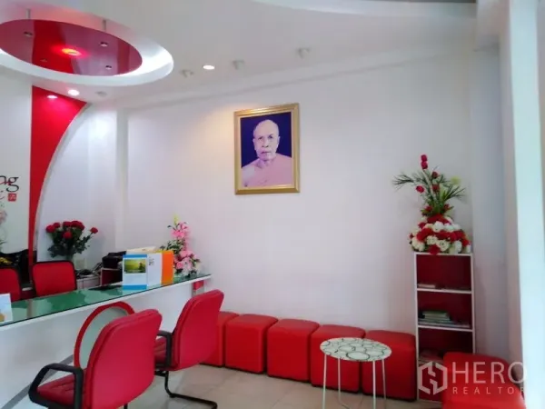 Office Space for sale in Bang Kapi, Bangkok - Modern reception area with red chairs, curved ceiling feature and floral décor.