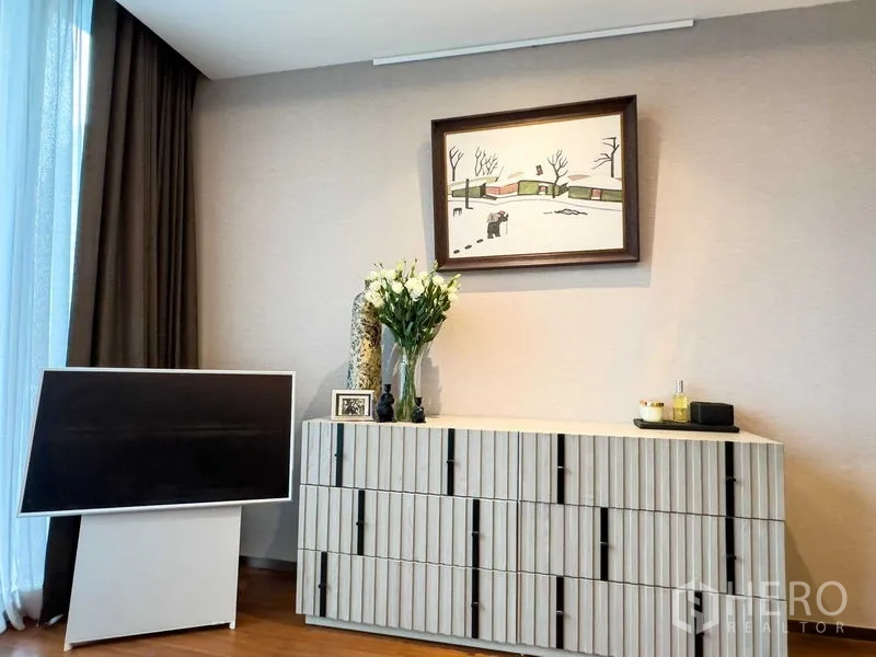 公寓 出售在Khlong Toei, Bangkok - 时尚角落，纹理玄关柜、装饰画与落地窗帘。