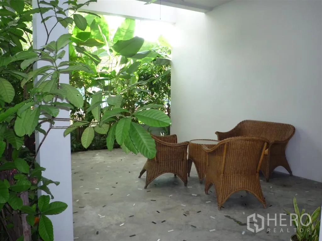 บ้าน ให้เช่าในKhan Na Yao, Bangkok - ระเบียงร่มรื่นพร้อมชุดหวาย และวิวต้นไม้เขียวขจี