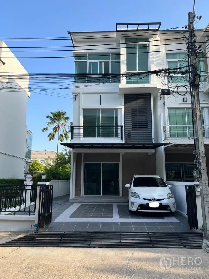 Townhouse for rent in Prawet, Bangkok - Three-storey townhouse exterior with carport and driveway.