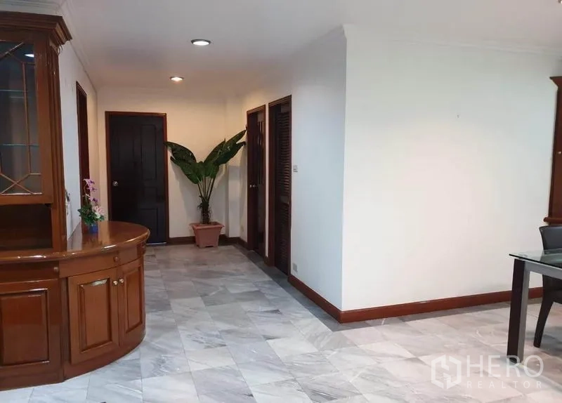 公寓 出租或出售在Watthana, Bangkok - 走廊铺石材地面，带木质边柜与盆栽。