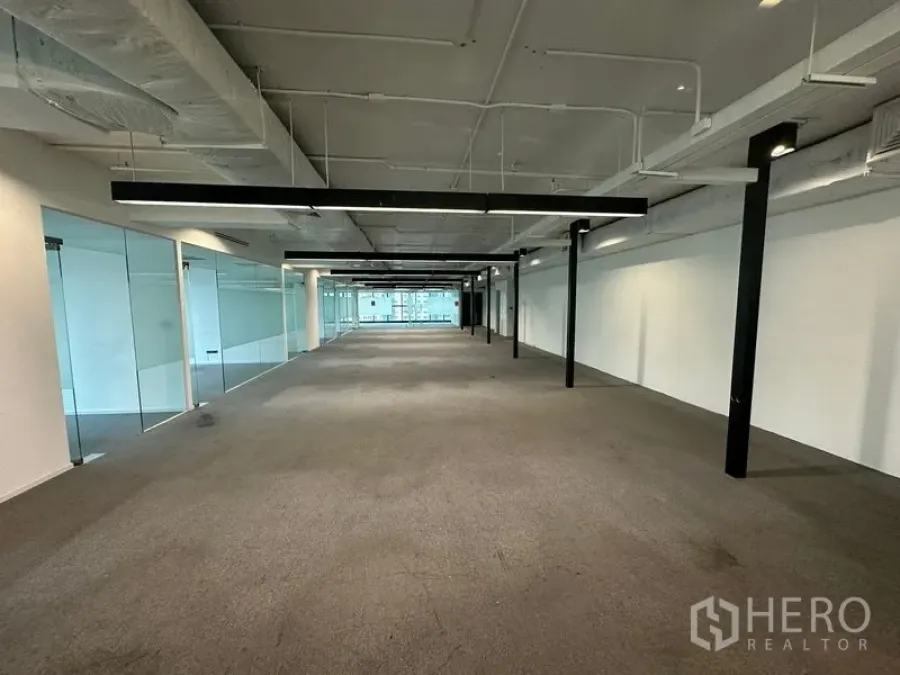 Office Space for rent - Deep open-plan floor plate with exposed services and black beams.