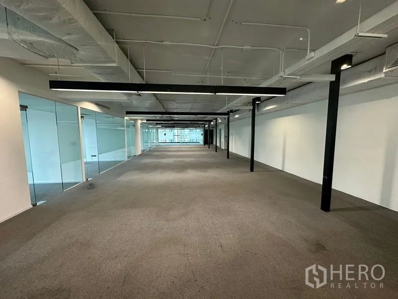Office Space for rent - Deep open-plan floor plate with exposed services and black beams.
