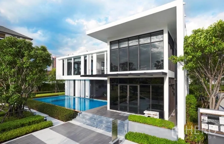 Detached House for rent in Bang Na, Bangkok - Modern estate clubhouse with large outdoor swimming pool and glass facade.