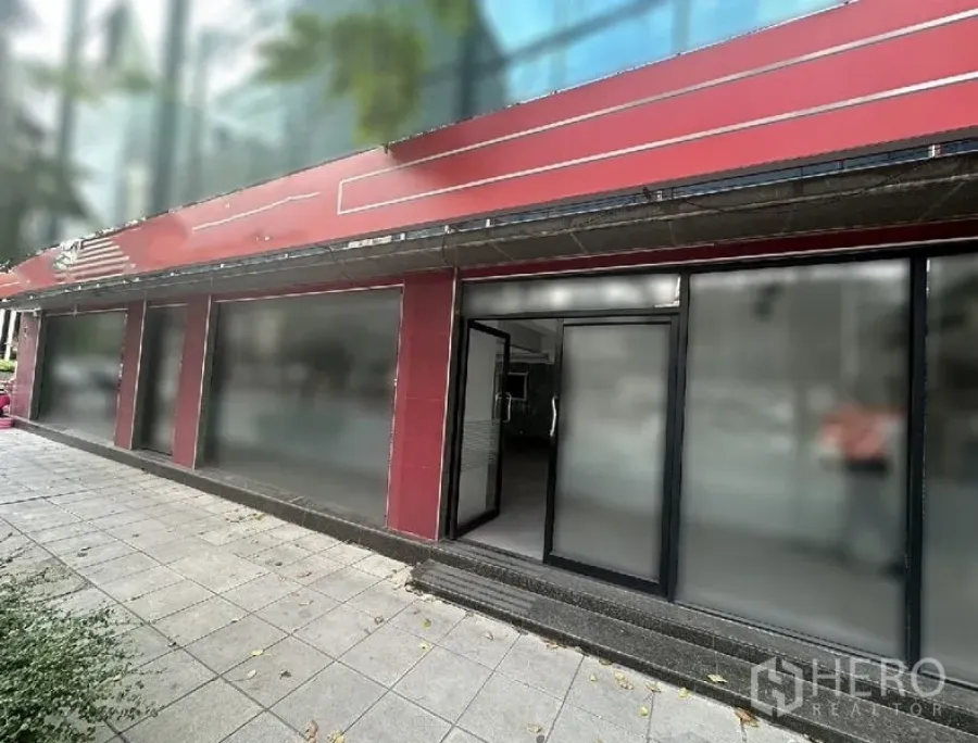 零售空间 出租在Bang Rak, Bangkok - 临街店面，红色立面，黑色玻璃门框，宽阔人行道。