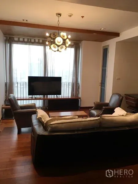 คอนโด ให้เช่าหรือขายในKhlong Toei, Bangkok - พื้นที่นั่งเล่นสว่างไสว มีหน้าต่างสูงจรดเพดาน ทีวี และโคมไฟในคอนโดกรุงเทพฯ