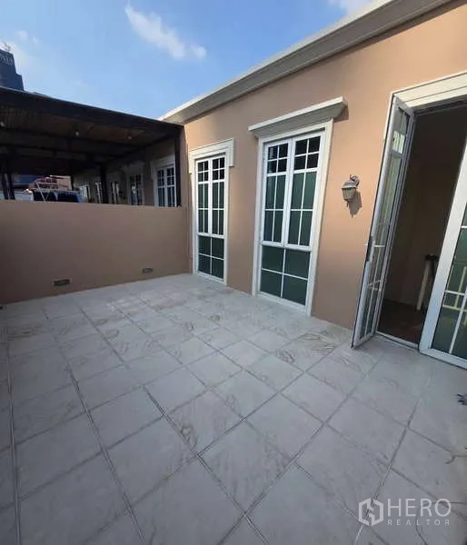 Townhouse for sale in Watthana, Bangkok - Private rooftop terrace with French doors and tiled flooring.