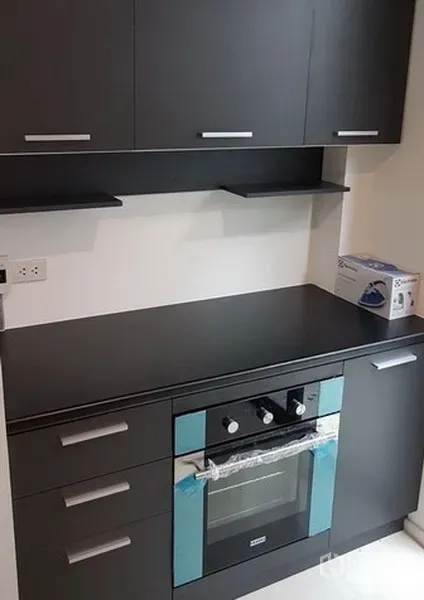 独立式住宅 出租在Prawet, Bangkok - 内置烤箱与哑光黑色台面特写，上方设收纳柜。