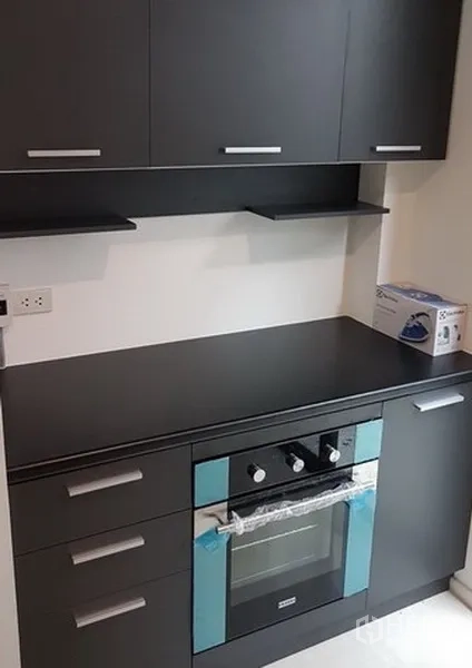 独立式住宅 出租在Prawet, Bangkok - 内置烤箱与哑光黑色台面特写，上方设收纳柜。