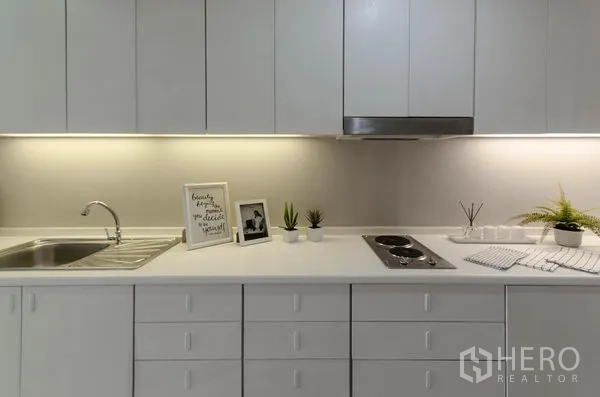 คอนโด ให้เช่าในWatthana, Bangkok - ครัวบิลท์อินสีขาว เคาน์เตอร์ยาว ซิงก์และเตาไฟฟ้าพร้อมไฟใต้ตู้