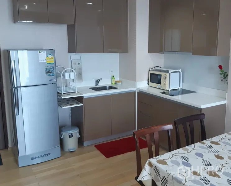 คอนโด ให้เช่าในKhlong Toei, Bangkok - ครัวรูปตัวแอล ตู้ลอยเงา ตู้เย็นสแตนเลส ไมโครเวฟ และชุดโต๊ะอาหาร