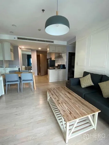 Condominium for rent in Khlong Toei, Bangkok - Open-plan living and dining room with sofa, wood coffee table, dining set and pendant lamp.