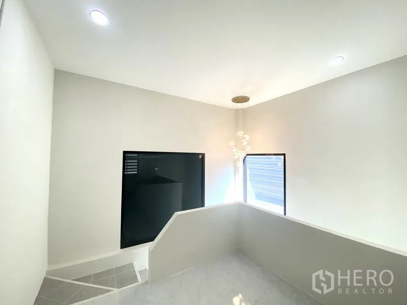 货栈 出租在Mueang Pathum Thani, Pathum Thani - 楼梯平台，采光充足，现代吊灯与侧窗。