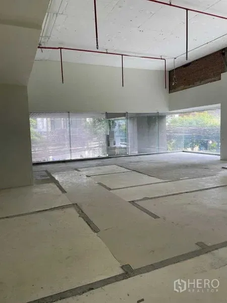 Office Space for rent in Watthana, Bangkok - High-ceiling office floor with exposed sprinkler piping and full-width glazing.