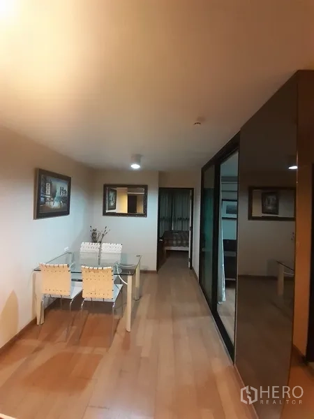 คอนโด ให้เช่าหรือขายในChatuchak, Bangkok - โถงรับประทานอาหาร โต๊ะกระจก งานศิลปะบนผนัง และตู้บิลต์อินกระจกเงา