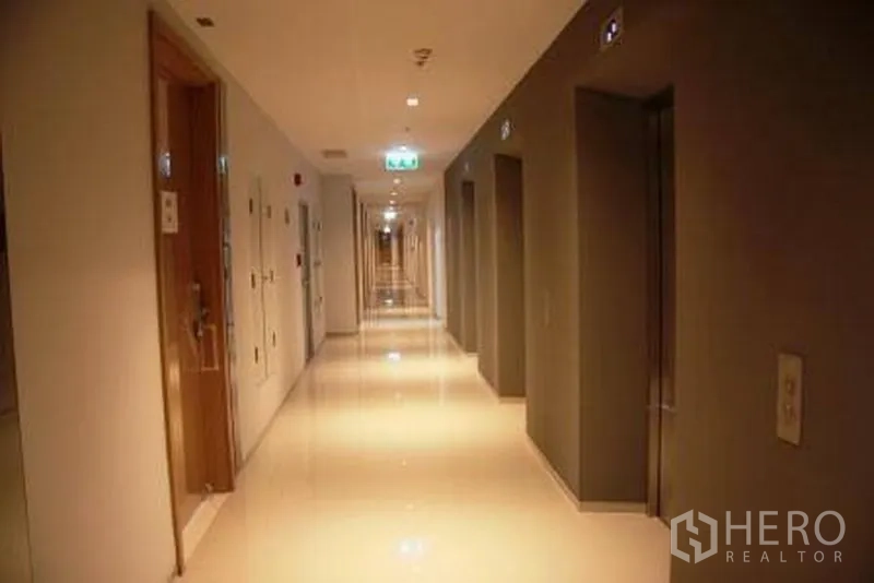 คอนโด ให้เช่าหรือขายในWatthana, Bangkok - โถงทางเดินคอนโดสว่าง พื้นกระเบื้องเงา พร้อมประตูลิฟต์และห้องพักเรียงราย