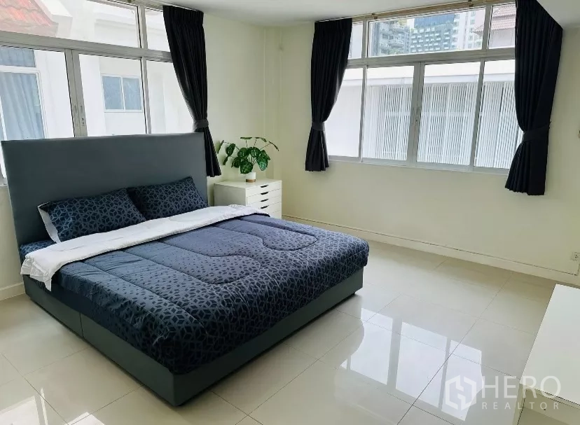 บ้าน ให้เช่า - ห้องนอนกว้าง เตียงบุหนังสีเข้ม และหน้าต่างบานใหญ่.