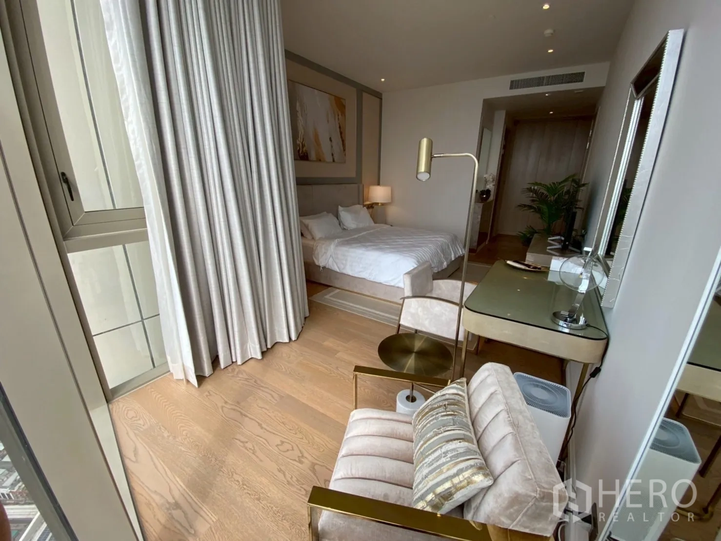 คอนโด ให้เช่าในKhlong San, Bangkok - ห้องนอนพร้อมโต๊ะเครื่องแป้งข้างหน้าต่างสูง ผ้าม่านยาว และพื้นไม้