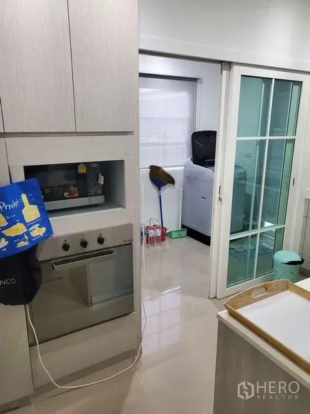 Detached House for sale in Bueng Kum, Bangkok - Built-in oven and cabinetry with a sliding glass door to the laundry area.