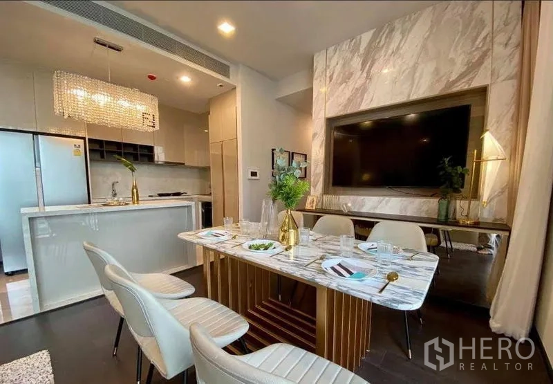 Condominium for rent in Watthana, Bangkok - Open-plan dining and modern kitchen with marble finishes and crystal pendant light.