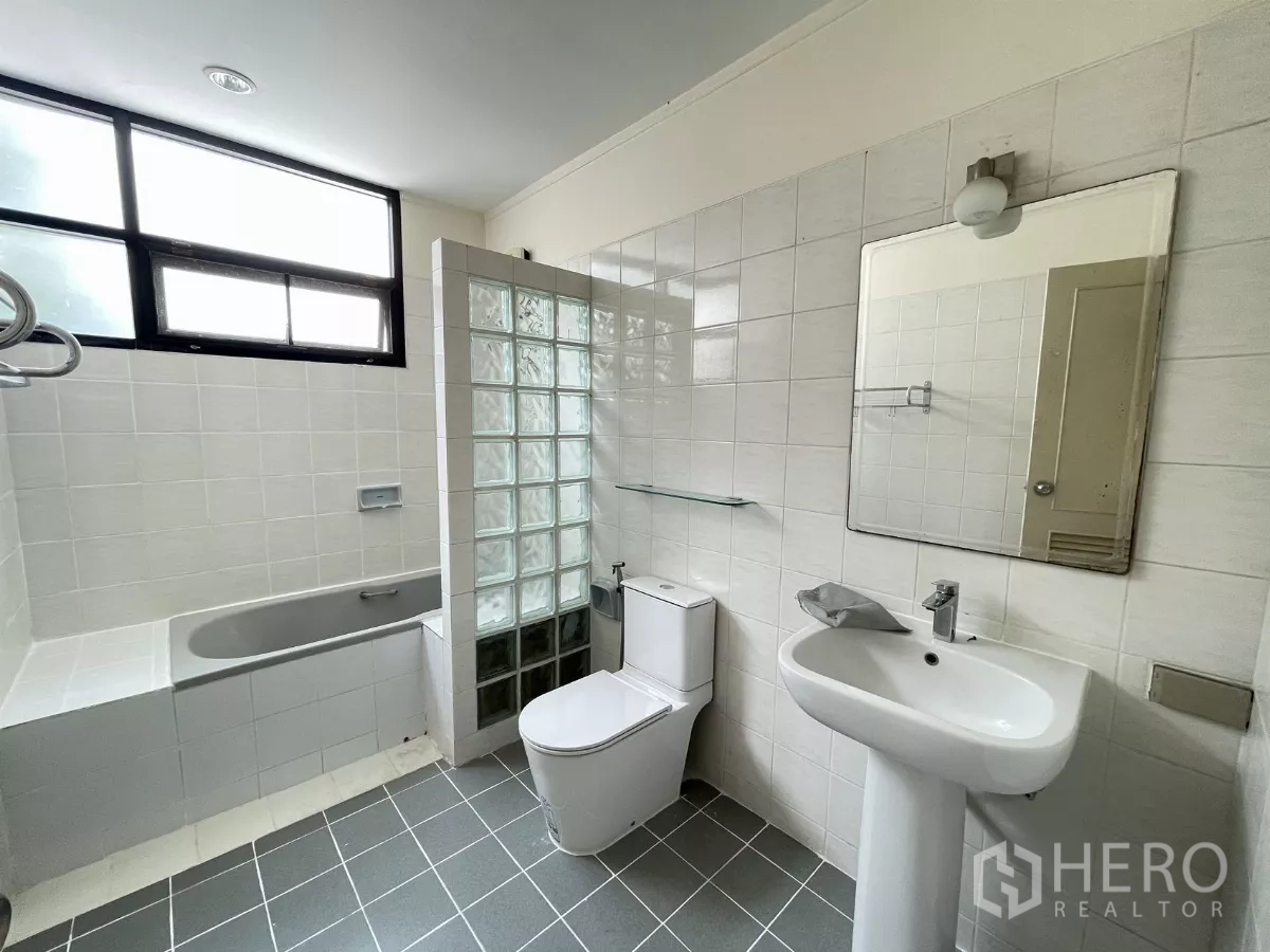 Detached House for rent in Chatuchak, Bangkok - Bathroom with bathtub, pedestal sink and glass‑block partition.