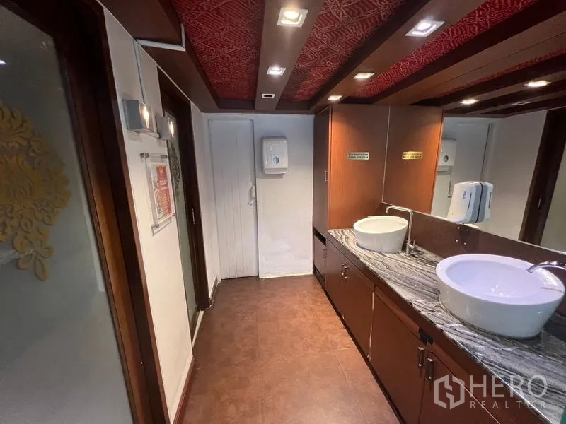 零售空间 出租或出售在Khlong Toei, Bangkok - 走廊式卫生间，双台盆、花岗岩台面与木质装饰。