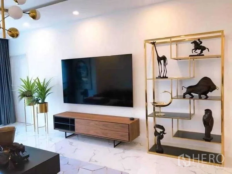 คอนโด ให้เช่าหรือขายในWatthana, Bangkok - ผนังทีวีจอใหญ่ พร้อมชั้นโชว์กรอบทองและกระถางต้นไม้ในบ้าน