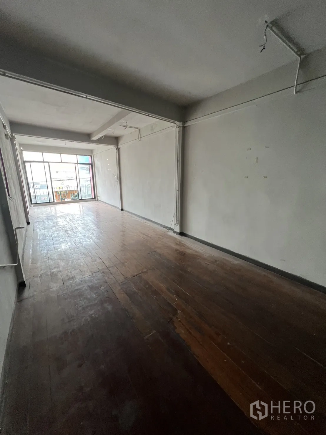 店屋 出租在Watthana, Bangkok - 楼上开放式平面，旧木地板与通阳台推拉门。