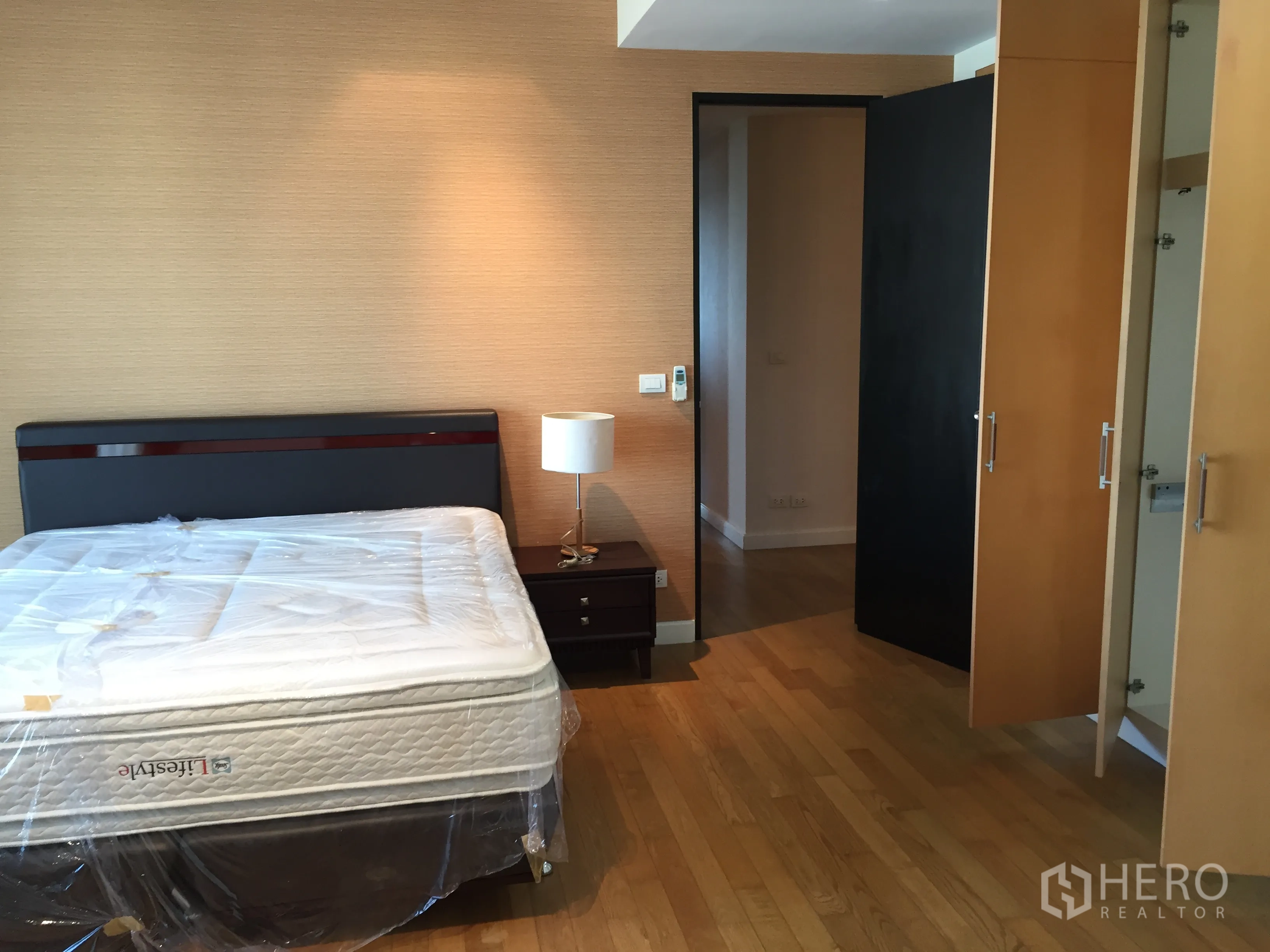 คอนโด ให้เช่าในWatthana, Bangkok - ห้องนอนที่สองพร้อมเตียง โต๊ะข้างเตียง และตู้เสื้อผ้าบิลต์อินบนพื้นไม้โทนอุ่น