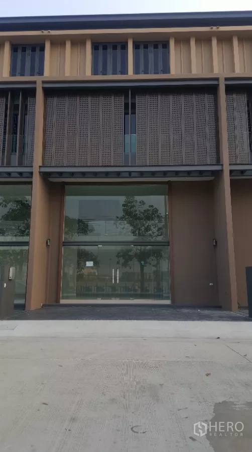 Home Office for rent in Pak Kret, Nonthaburi - Modern multi-level home office facade with full-height glass frontage, perforated metal screens, and a parking apron.