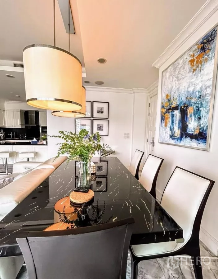 คอนโด ขายในWatthana, Bangkok - มุมรับประทานอาหารหรู โต๊ะหินอ่อนสีดำ โคมแขวนสมัยใหม่และงานศิลป์ ข้างครัวสว่าง