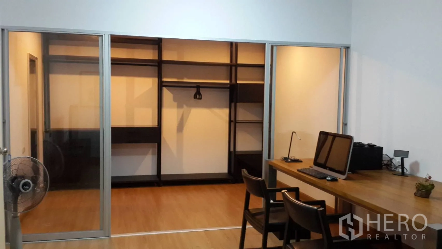 คอนโด ให้เช่าในHuai Khwang, Bangkok - ประตูกระจกบานเลื่อนเปิดสู่ห้องแต่งตัววอล์กอินพร้อมชั้นวาง ข้างโต๊ะทำงานที่บ้าน