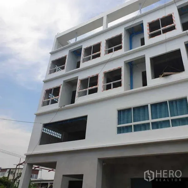 办公空间 出租或出售 - 白色多层办公楼外立面，窗框未完工并可见管线。