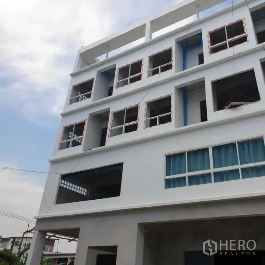 Office Space for rent or sale - Multi-storey white office building facade with open window bays and exposed piping.
