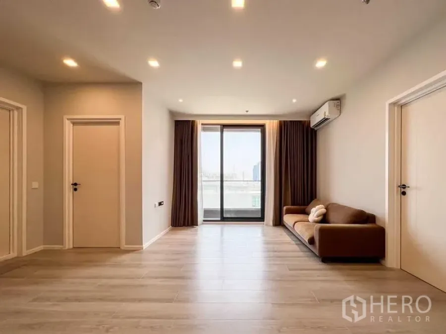 Condominium for rent or sale - Minimalist living room with sofa, recessed lighting and balcony doors.