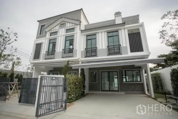 Townhouse for rent in Bang Phli, Samut Prakan - Modern three-storey townhouse exterior with gated entrance and covered parking.